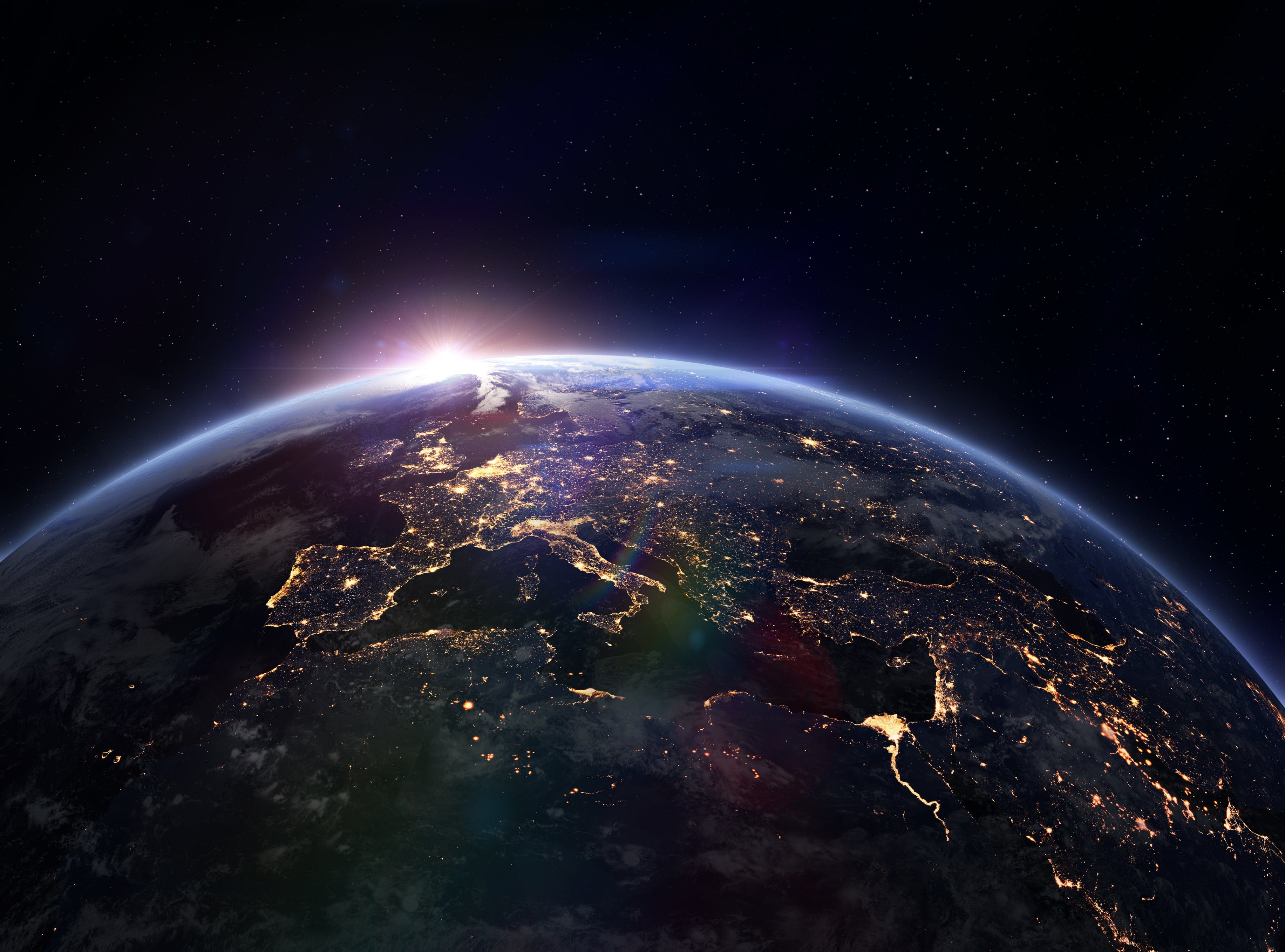 Vibrant Earth from space, nighttime cities of Europe illuminated, brilliant sunrise, thin blue atmosphere, dark starry sky