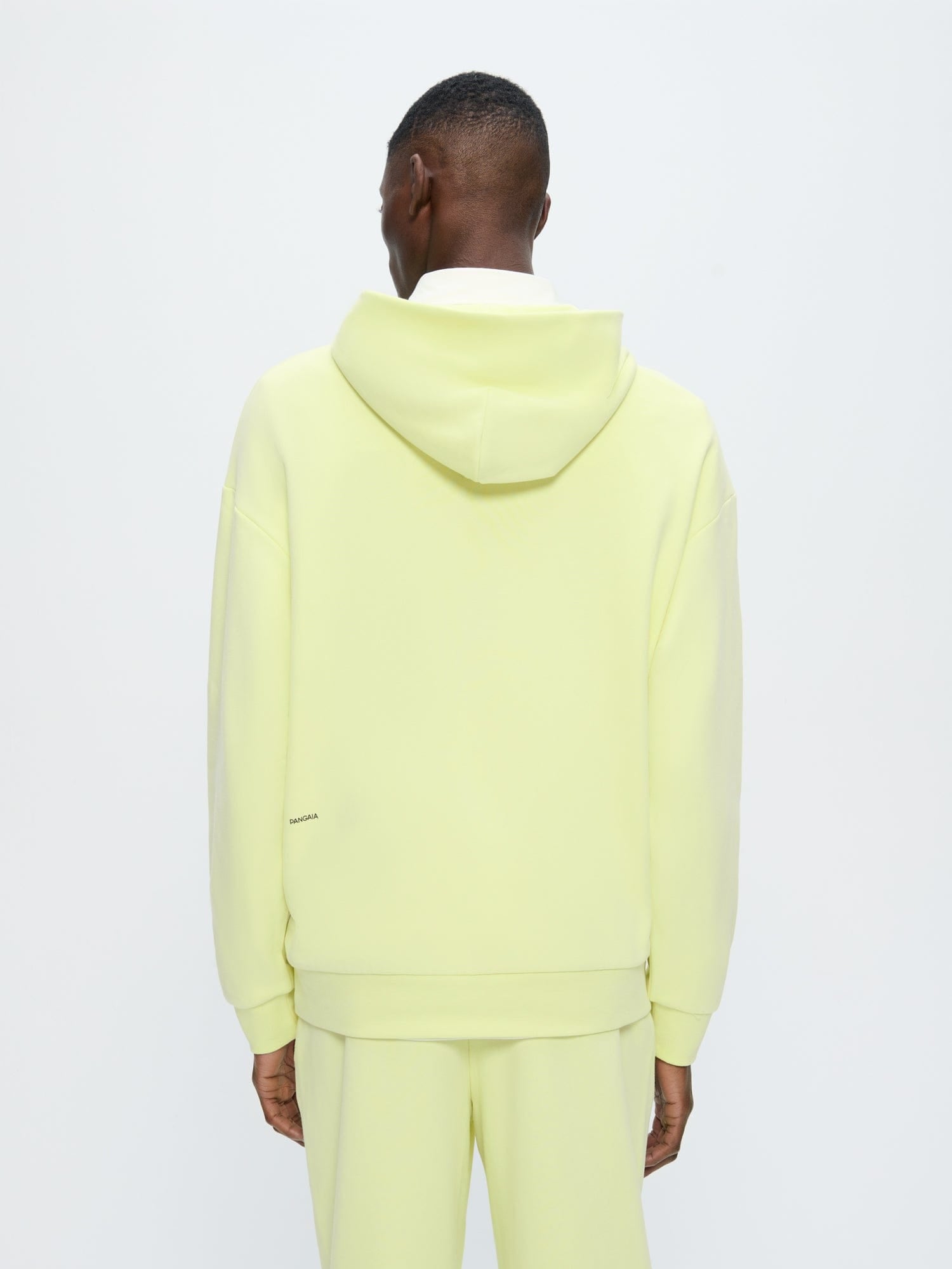 Mens 365 Midweight Hoodie Soft Lime, 100% organic cotton. Model back view, oversized boxy fit, hooded.