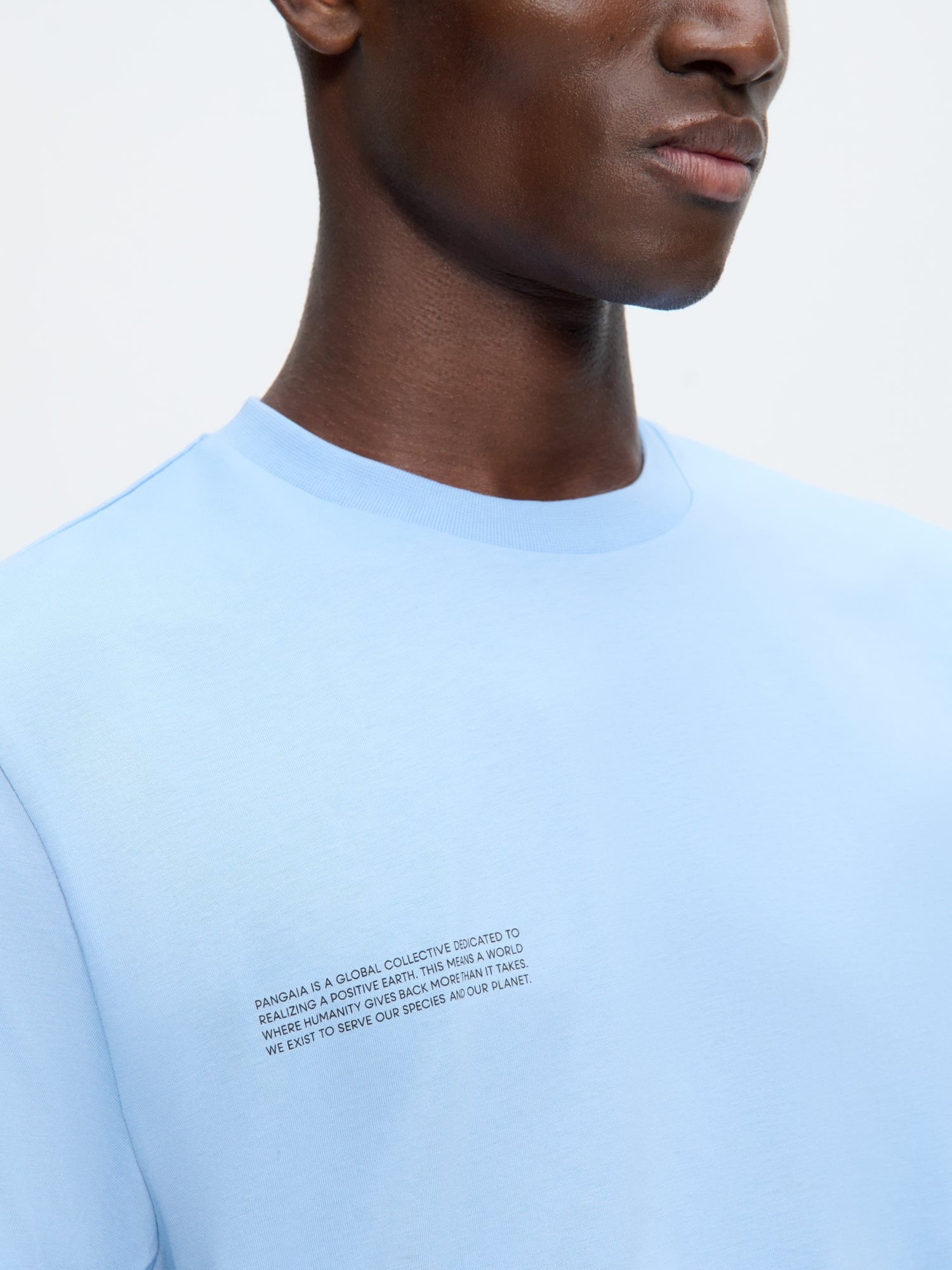 Mens 365 Midweight T-shirt, Dewdrop Blue organic cotton, oversized fit, crew neck. Close-up of model's chest with text