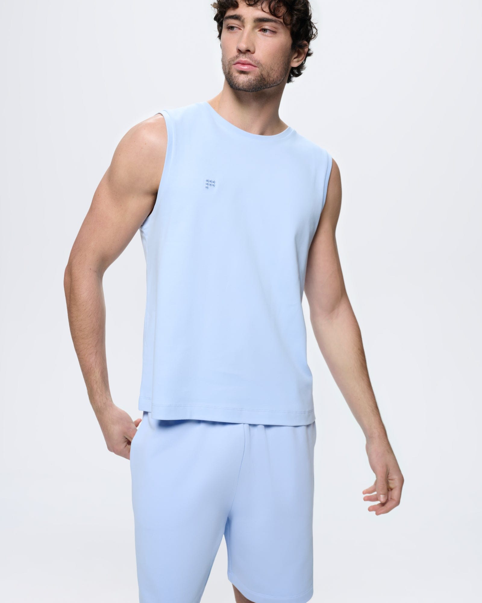 Mens Summer Sleeveless T-Shirt, Wildflower Blue 100% organic cotton, relaxed fit, crew neck, tonal logo, on model