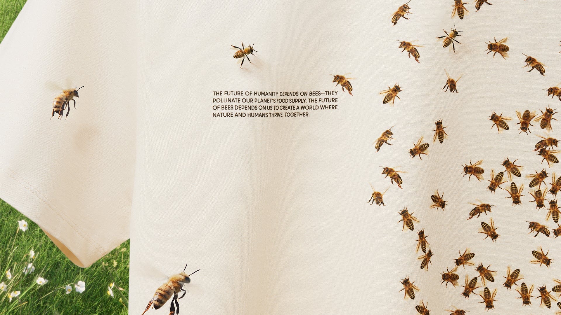 Ecru premium cotton t-shirt featuring realistic honey bee print and text about bee pollination, shown over grass