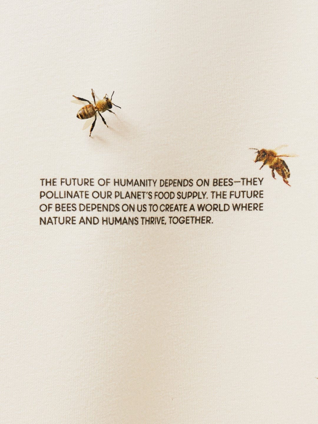 Soft cream knit fabric packshot detail with black text 'Future of Humanity Depends on Bees' and two detailed bees