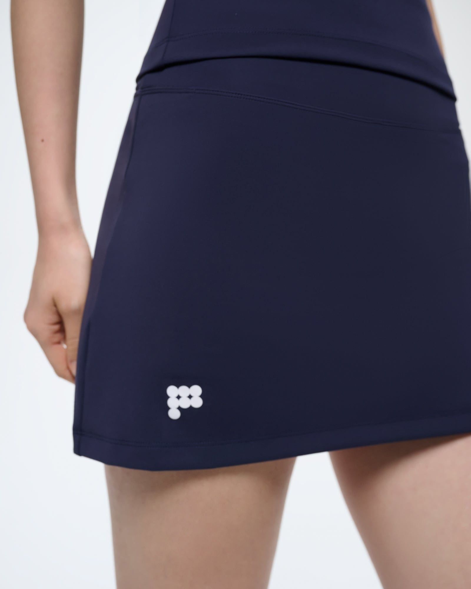 Premium Granite Navy Womens Court Side Skort. Ultra-close fit, buttery-soft bio-nylon performance skort with white logo detail