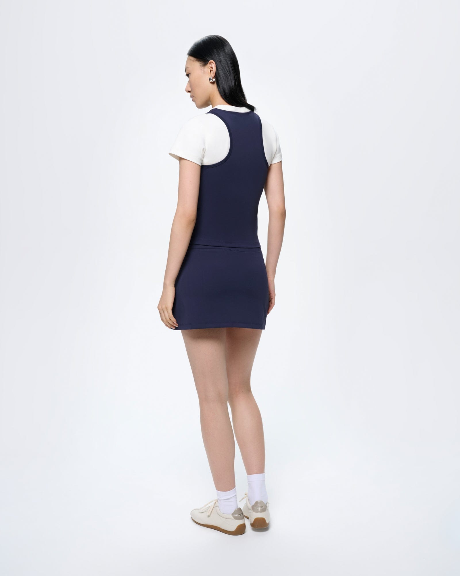 Womens Court Side Skort Granite Navy on model, back view. Flattering, ultra-close fit, short athletic skirt