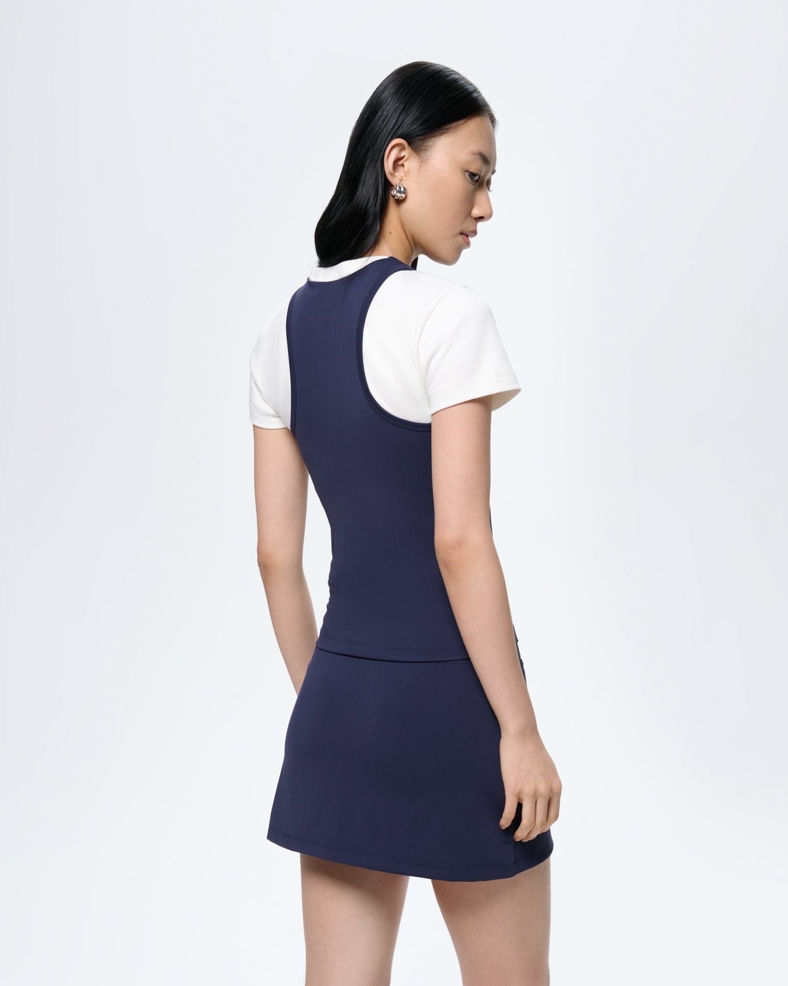 Womens Court Side Tank Top Granite Navy, ultra-close fit. Model wears buttery-soft bio-based nylon active tank over white tee