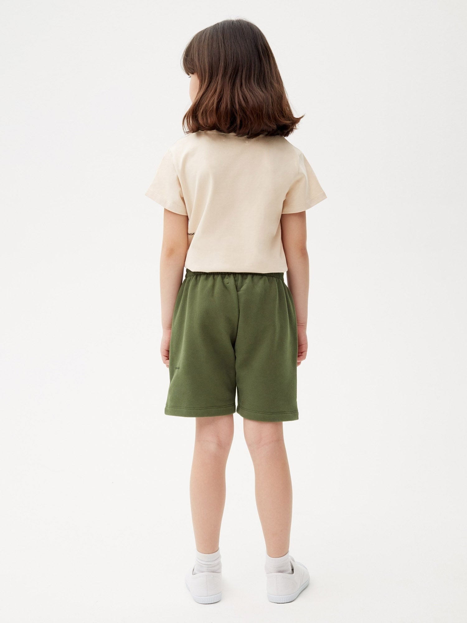 Rosemary green midweight organic cotton kids' long shorts with elastic waistband, seen on child model from back
